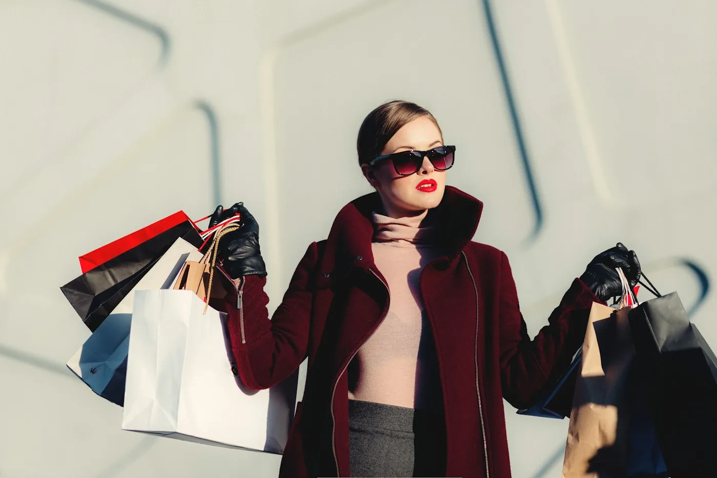 Woman wearing a burgundy coat and carrying shopping bags