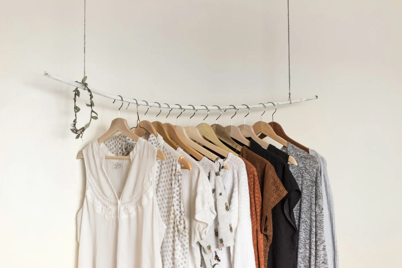 Neutral shirts and dresses arranged on a clothing rail