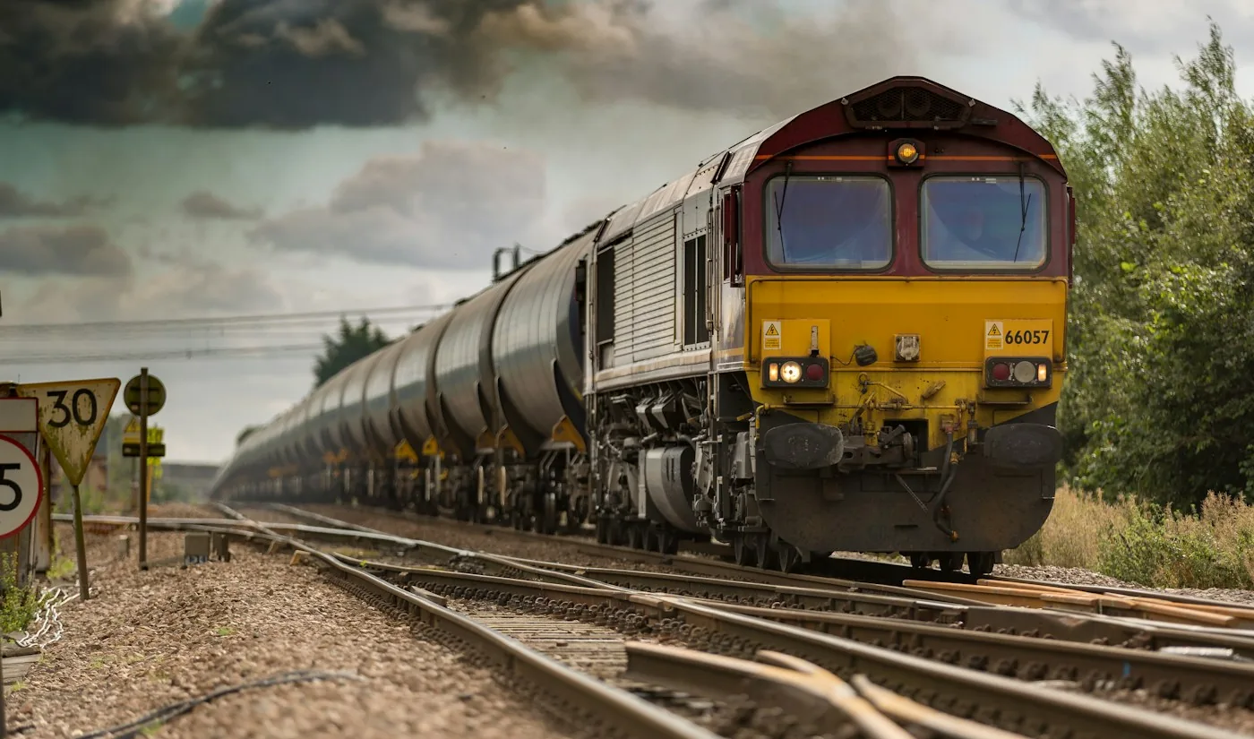Freight locomotive pulling tank wagons along railway tracks
