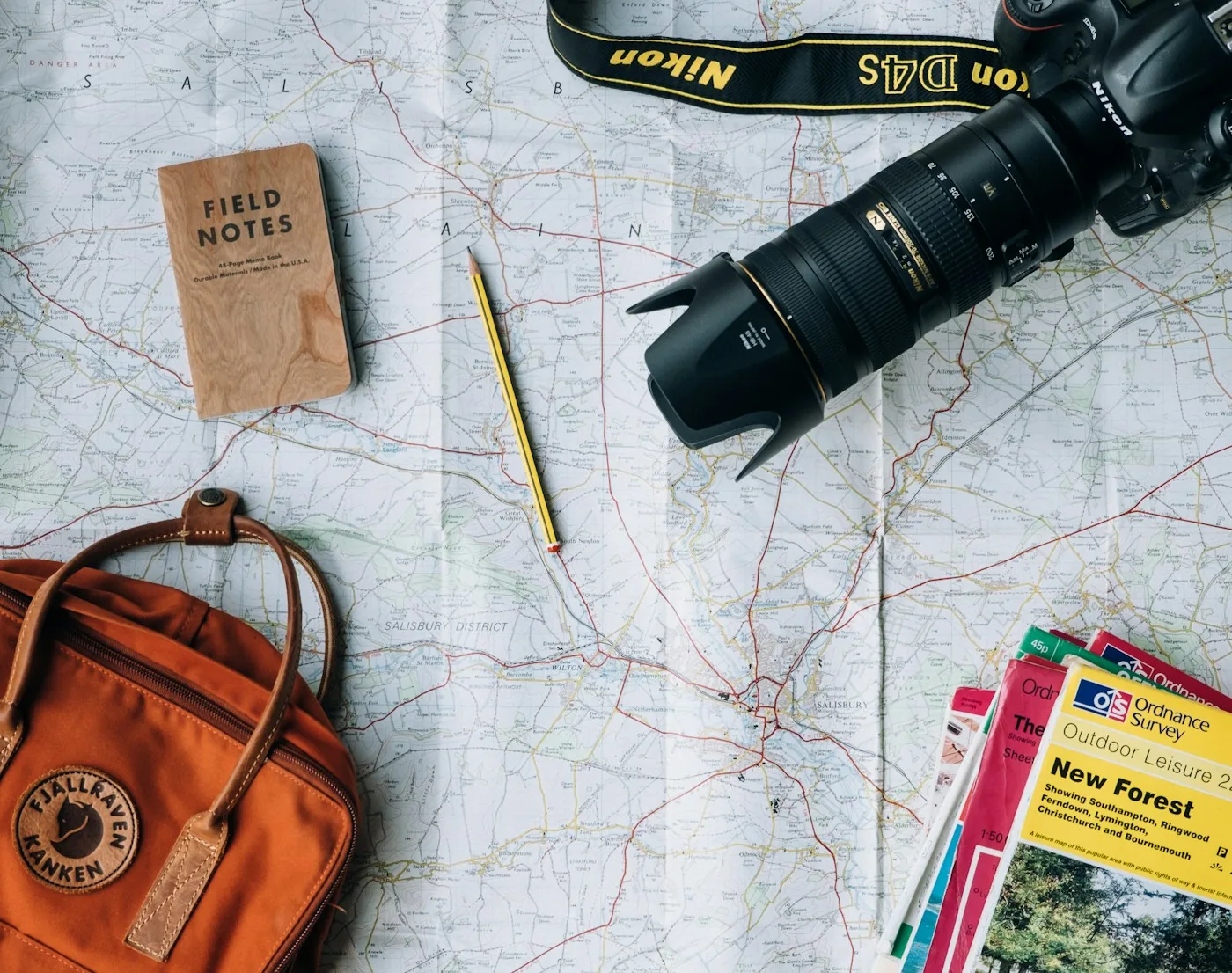 Camera and small travel bag laid on a map